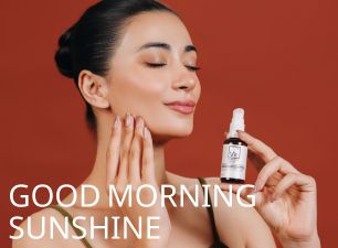 Model applying Dr. Elements morning serum while holding the dropper bottle against a warm background